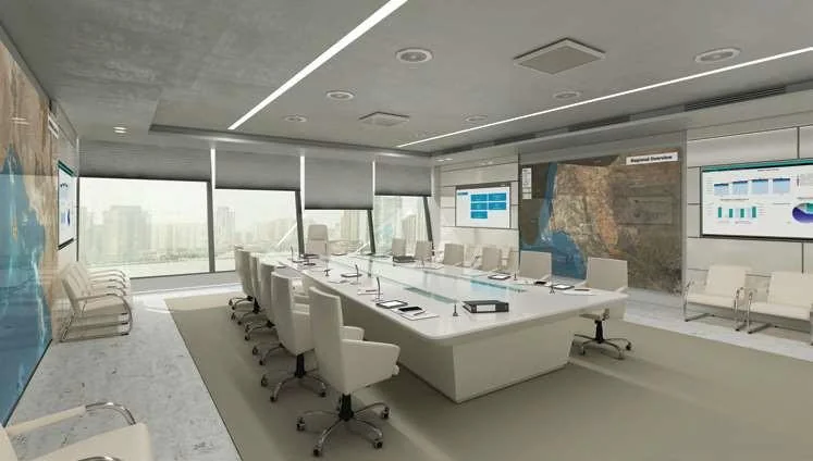 Bright meeting room with a long table, display screens and full-height glazing.