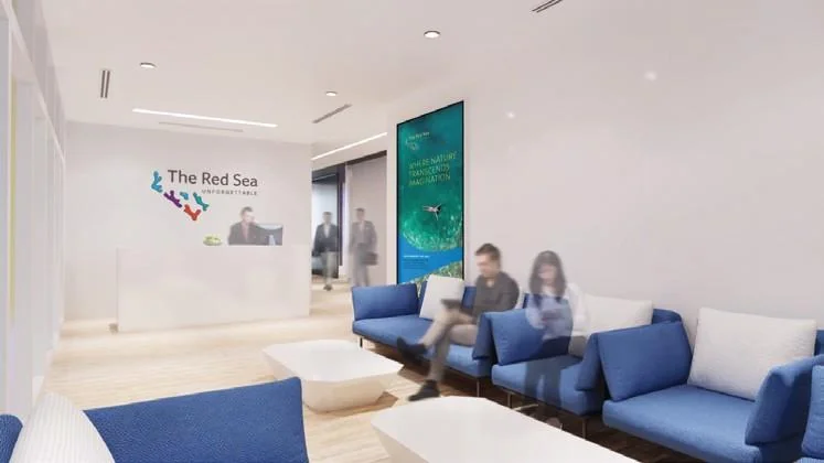 Reception visualisation with blue seating and a branded wall.
